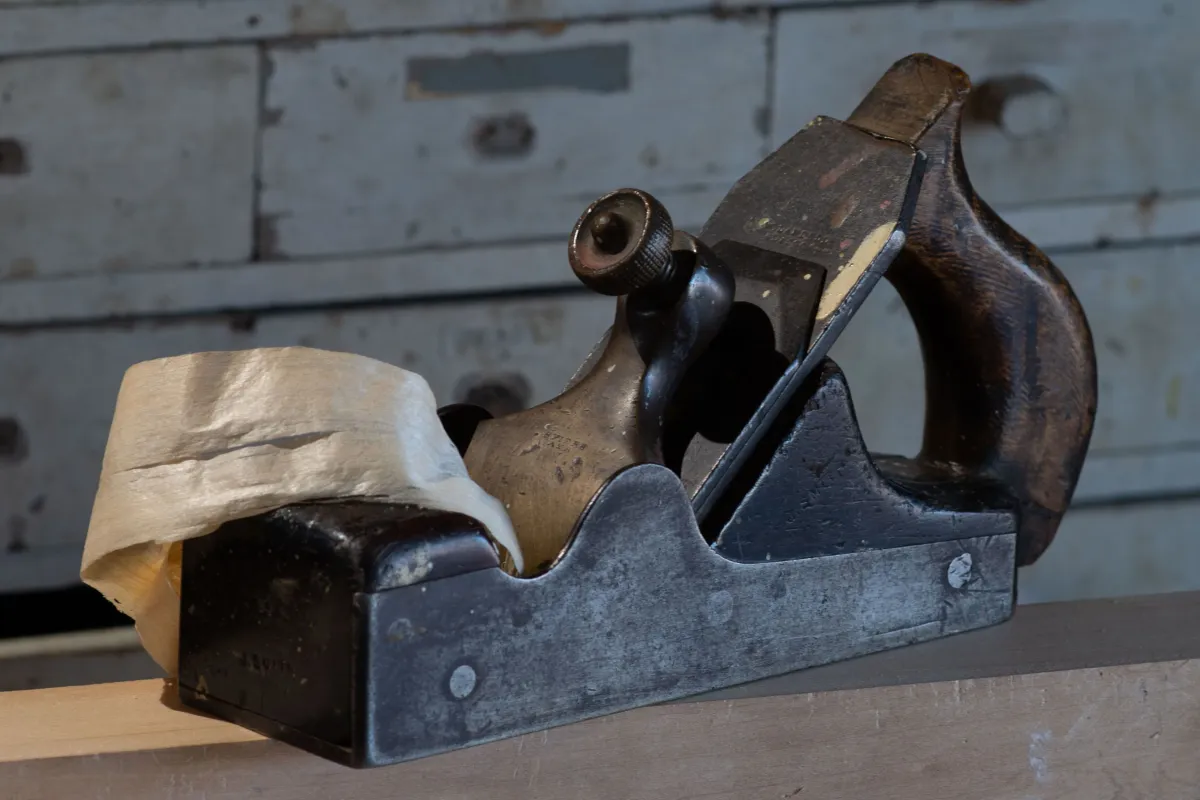 Collection of vintage Stanley Bailey bench planes numbered 3 through 7 arranged on a wooden workbench